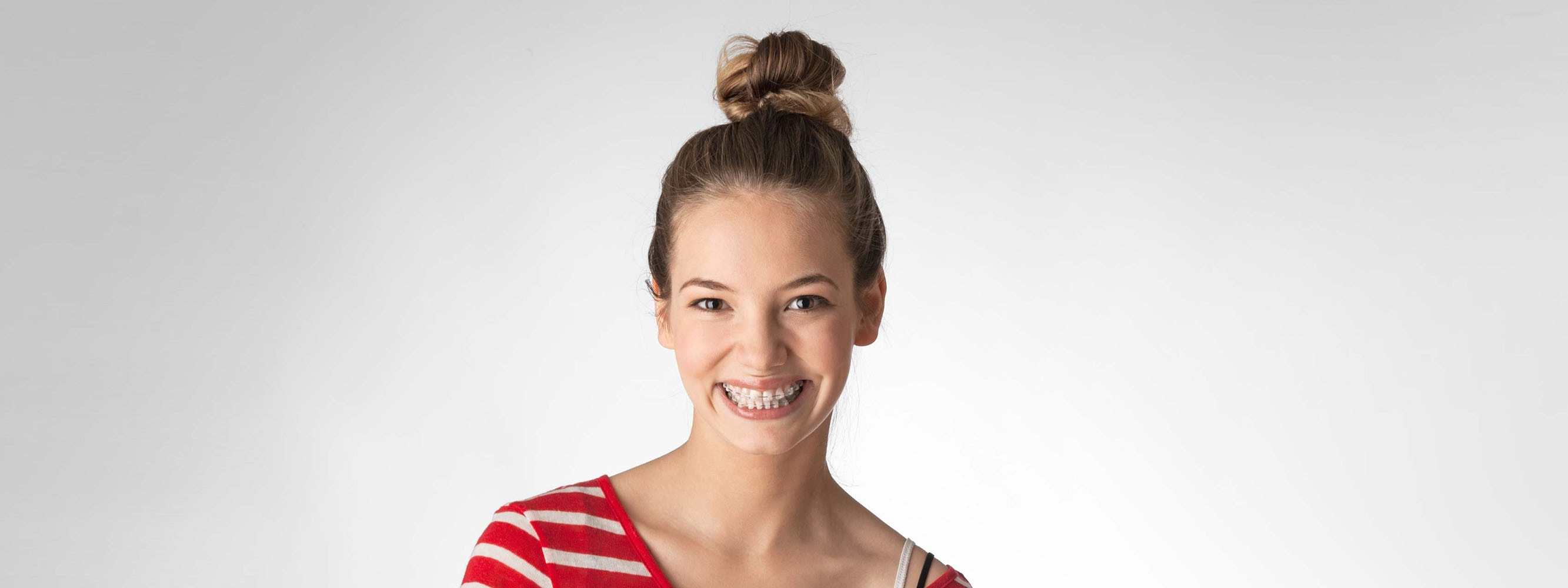 Lächelnde Teenagerin mit durchsichtige Zahnspangen