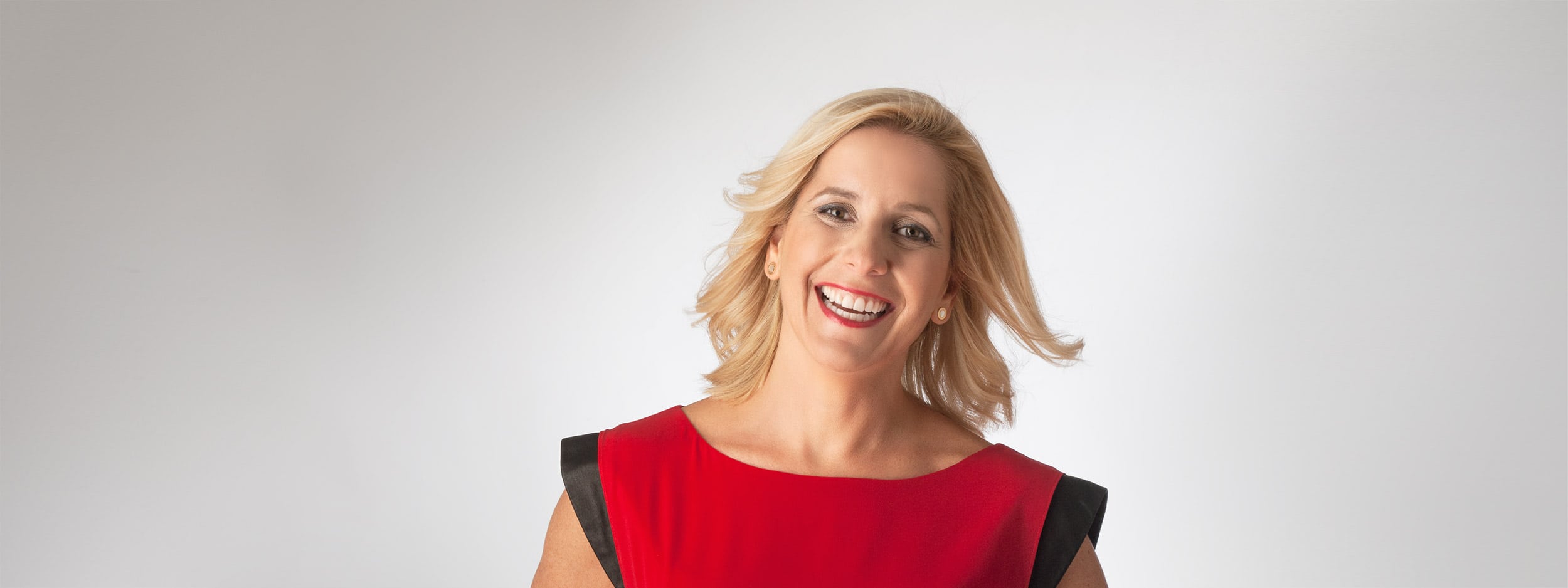 Woman in red dress smiling with great teeth